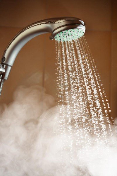 A shower running, with steam forming from the hot water